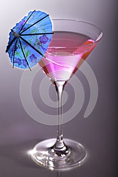 Party girl. Pink party cocktail with blue umbrella